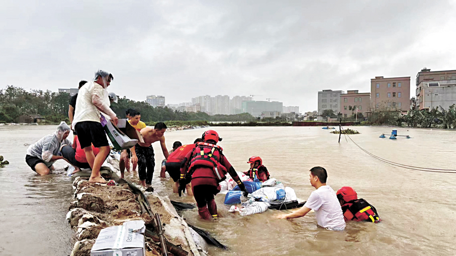 ●暴雨期間，消防救援人員在揭陽市惠來縣聯合當地民眾全力開展沙袋築堤、加固堤壩搶險作業。 中新社