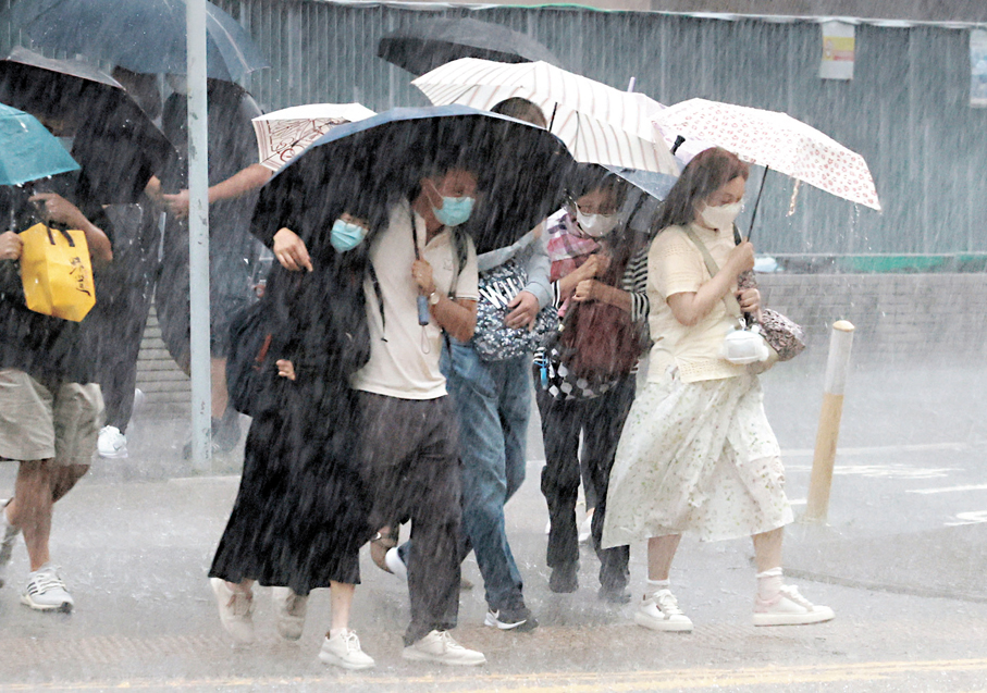 ●本港昨日被暴雨籠罩，天文台兩度發出黑色暴雨警告信號，市區雨勢很大，市民外出帶備雨傘過馬路亦顯得狼狽。 香港文匯報記者郭木又  攝