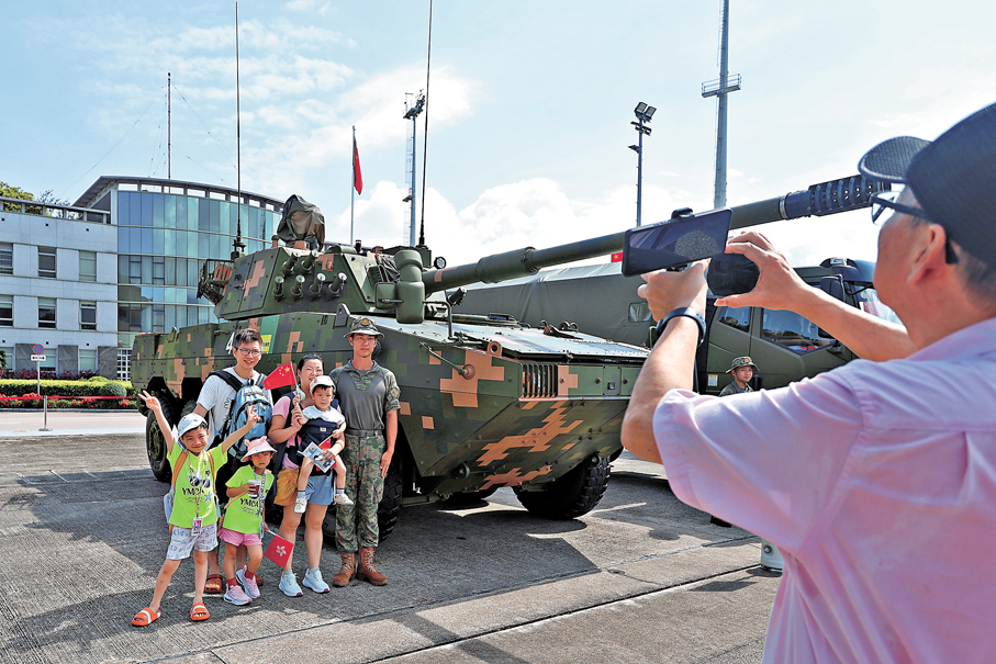 ●市民在陸軍裝備區與坦克及士兵合影。香港文匯報記者黃艾力  攝