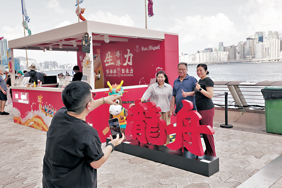 ●香港國際龍舟節昨日續於尖沙咀星光大道舉行，現場設有「龍舟美食街」及「啤酒樂園」，吸引旅客帶同父親到來打卡。 香港文匯報記者北山彥  攝