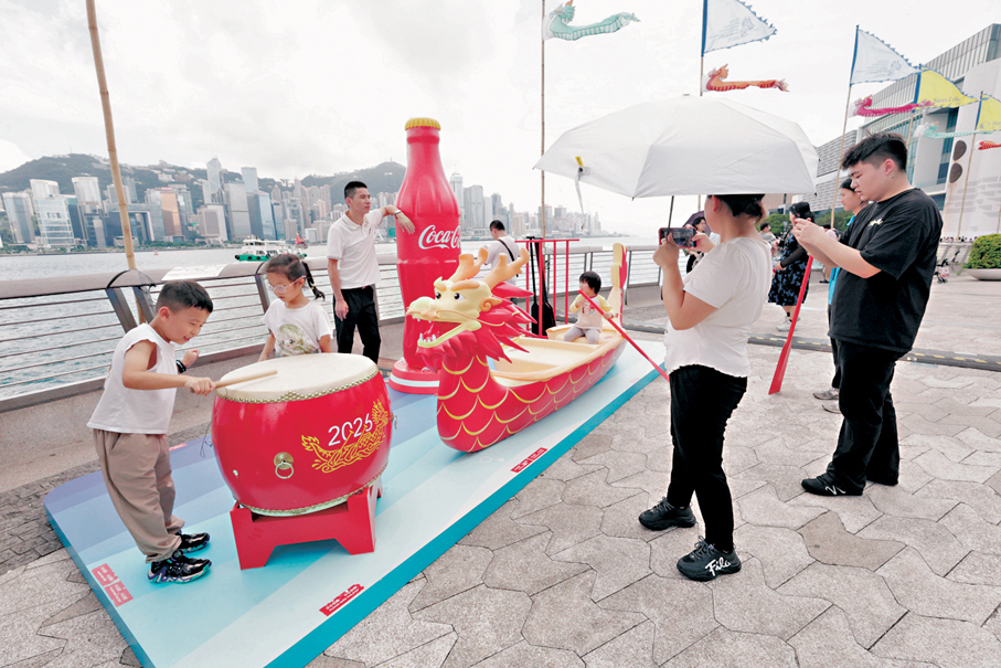 ●香港國際龍舟節昨日續於尖沙咀星光大道舉行，現場設有「龍舟美食街」及「啤酒樂園」，吸引旅客帶同父親到來打卡。 香港文匯報記者北山彥  攝