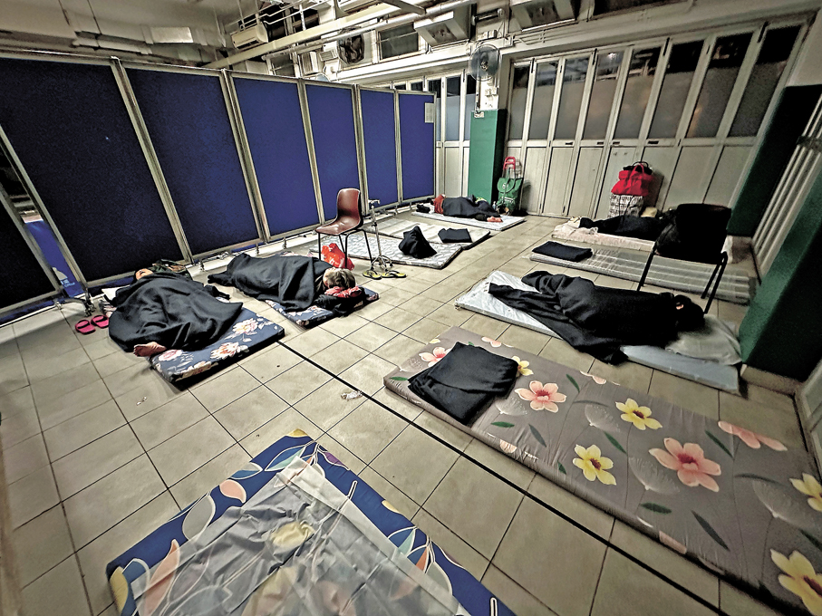 ●梁顯利油麻地社區中心女士睡眠區有屏風分隔，職員已將床位鋪好。香港文匯報記者林泉   攝