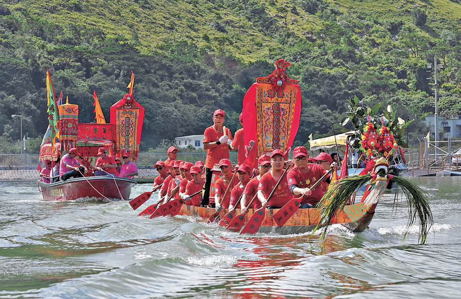●圖為龍舟拖着「神艇」巡遊水道。資料圖片