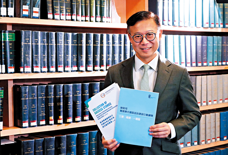 ●張國鈞手持第二輯《香港專業服務助力中國內地企業出海成功案例實錄》將於下月正式出版。 香港文匯報記者曾興偉  攝