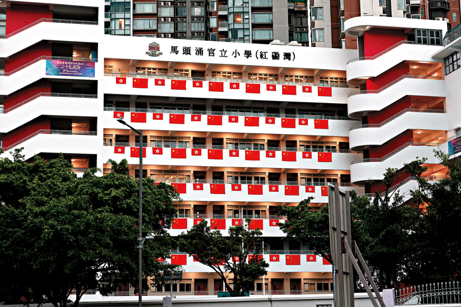 ●學校掛上國旗區旗，形成一幅旗海。香港文匯報記者黃艾力  攝