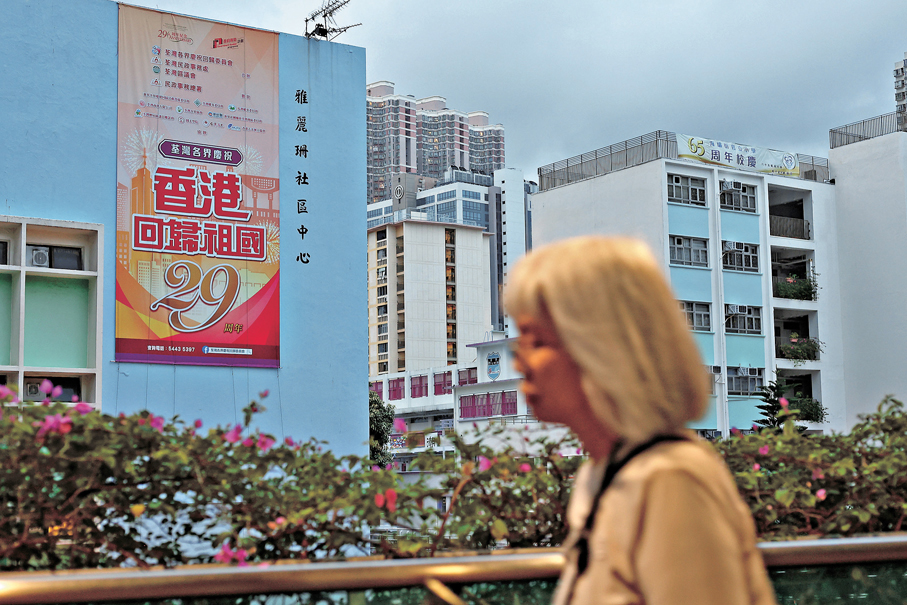 ●社區中心外掛上回歸祖國29周年直幡，分外搶眼。香港文匯報記者黃艾力  攝