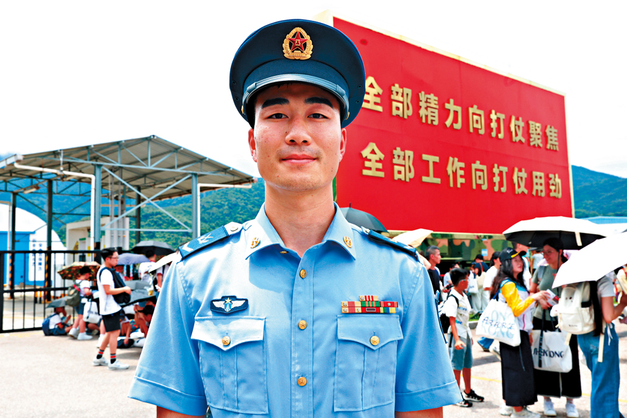 ●駐香港部隊空軍中士王連旭介紹槍械展示內容。 香港文匯報記者萬霜靈  攝