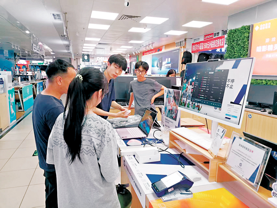 ●華強北賽格電子市場一品牌電腦商戶為客戶測試手提電腦。  香港文匯報記者李昌鴻  攝