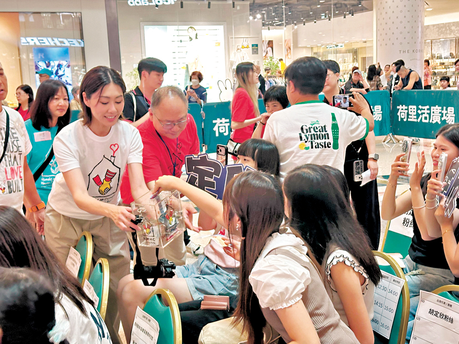 ●胡定欣落力向台下觀眾售賣獎券。香港文匯報記者子棠  攝