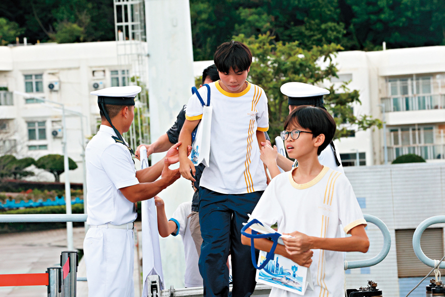 ●每當有人上落舷梯，海軍官兵一邊喊着小心腳下，一邊伸手扶市民上落。 香港文匯報記者萬霜靈  攝