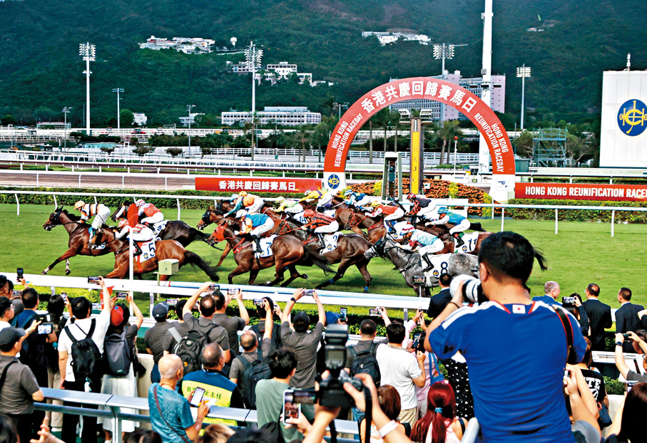 ●馬會在沙田馬場舉行「香港共慶回歸賽馬日」，當競賽馬匹抵達終點時，馬迷紛紛舉機拍照。 香港文匯報記者黃艾力  攝