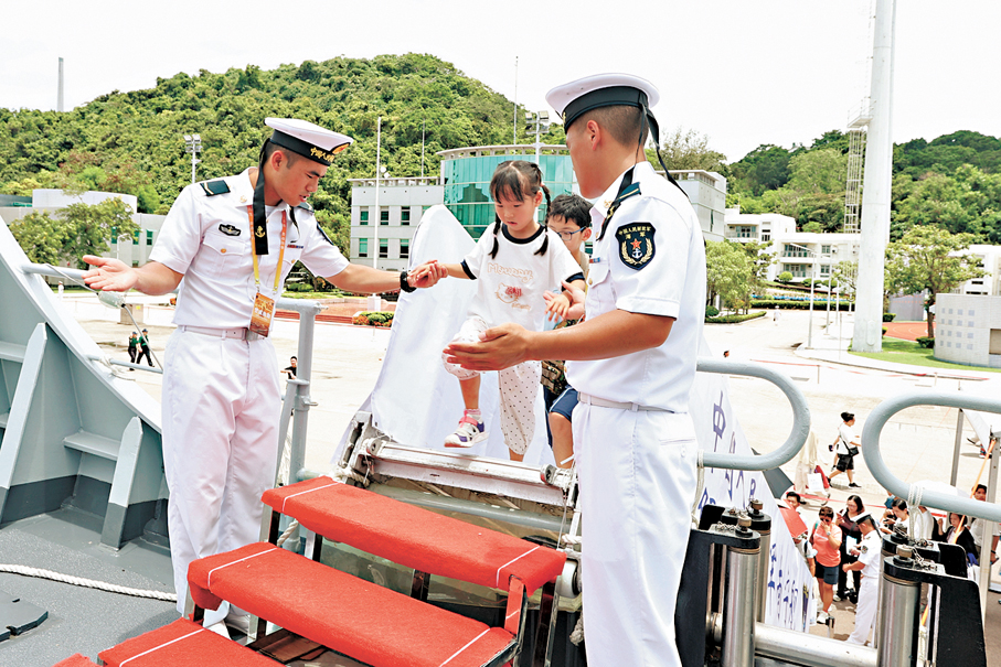 ●官兵扶小朋友登艦。