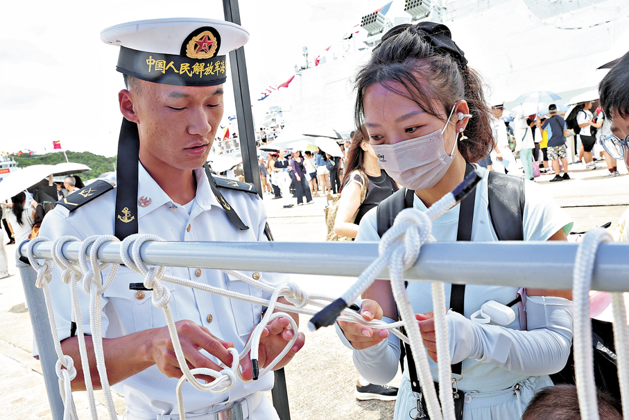 耐心指導●官兵教導參觀者打海軍繩結。   香港文匯報記者萬霜靈  攝