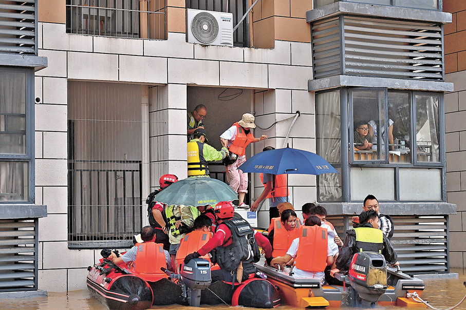 ●7月8日，救援人員在廣西貴港市西江教育園區轉移被困師生。 新華社