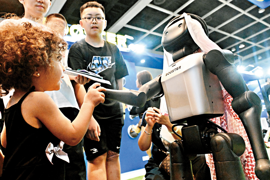 ●圖為一名外籍小女孩與機器人互動。資料圖片