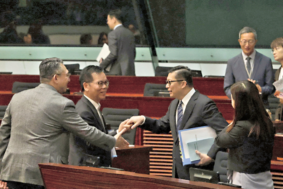 ●立法會昨日三讀通過《皇崗口岸港方口岸區條例草案》後，議員向保安局局長鄧炳強道賀。香港文匯報記者北山彥  攝