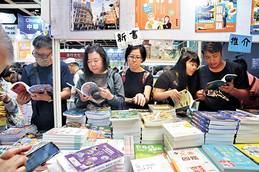 ●大家在書攤前對各種書籍仔細比評，看看有什麼心頭好。 香港文匯報記者郭木又  攝 