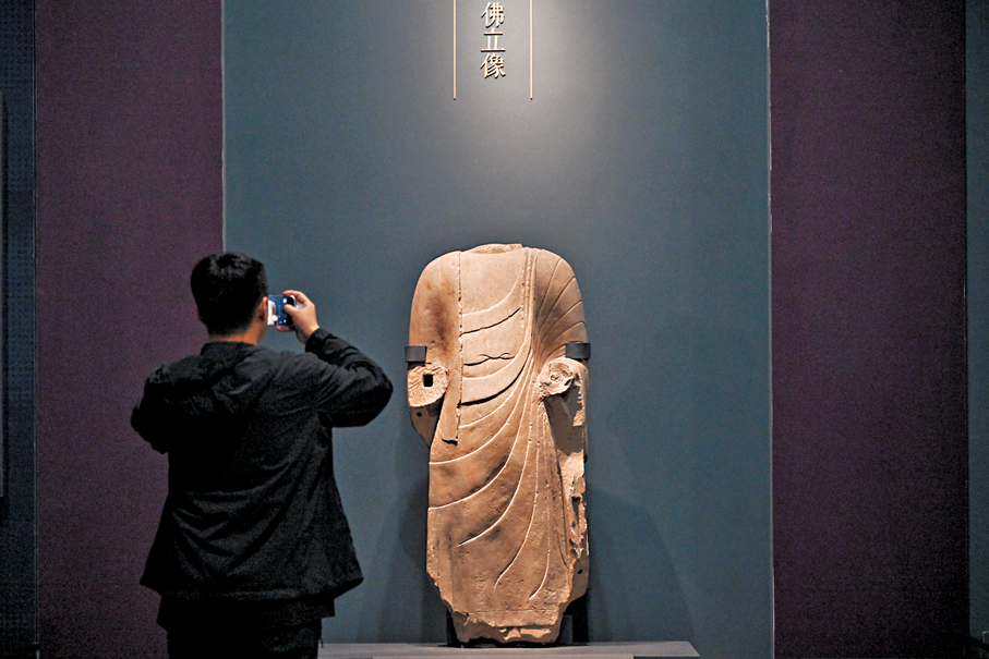 ●市民參觀汾陽市汾陽博物館館藏佛立像。中新社
