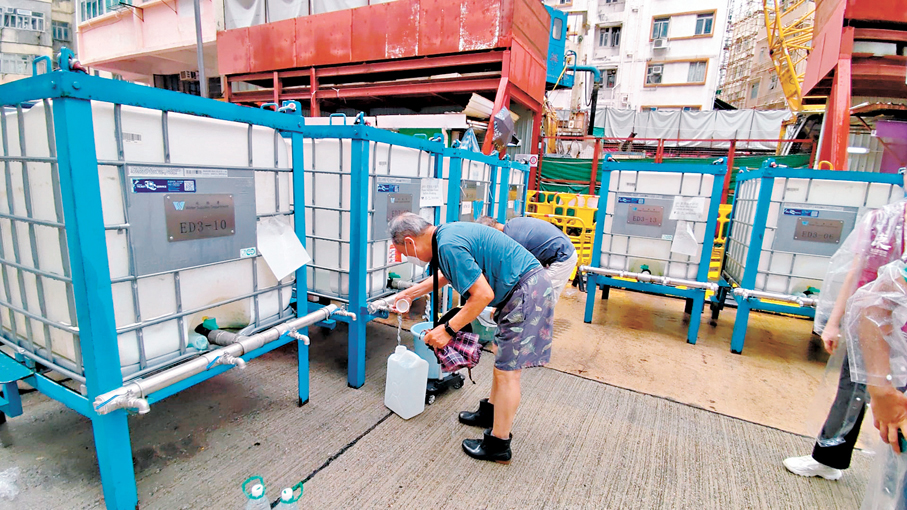 ●受停水影響居民到街邊水箱取水。香港文匯報記者鄺福強  攝