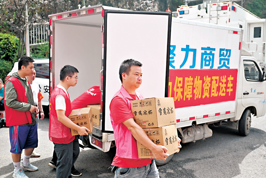 ●7月19日，志願者在重慶彭水縣崩塌災害救援現場附近搬運物資。 新華社