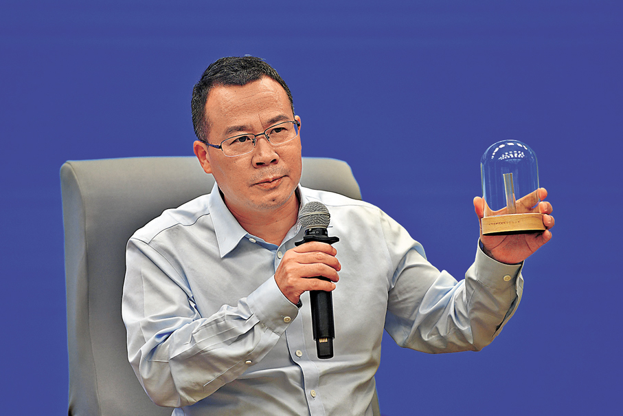 ●長飛光纖副總裁王瑞春介紹獲得國家大獎的光纖預製棒。 香港文匯報記者歐陽思柔  攝