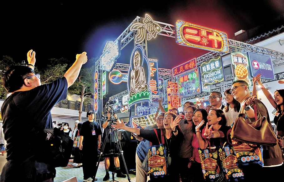 ●昂坪360舉行二十周年纜車夜航體驗首航典禮。圖為亮燈儀式後，市民在懷舊LED招牌前拍照留念。   中通社