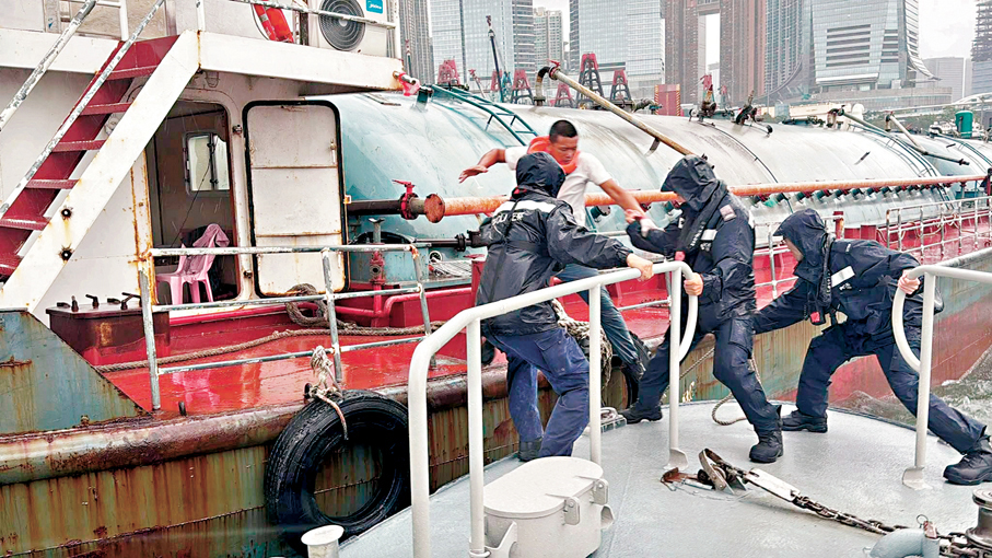 ●消防及水警人員在油麻地避風塘成功協助3名遇險的貨船船員安全登上水警輪。香港警察Fb圖片