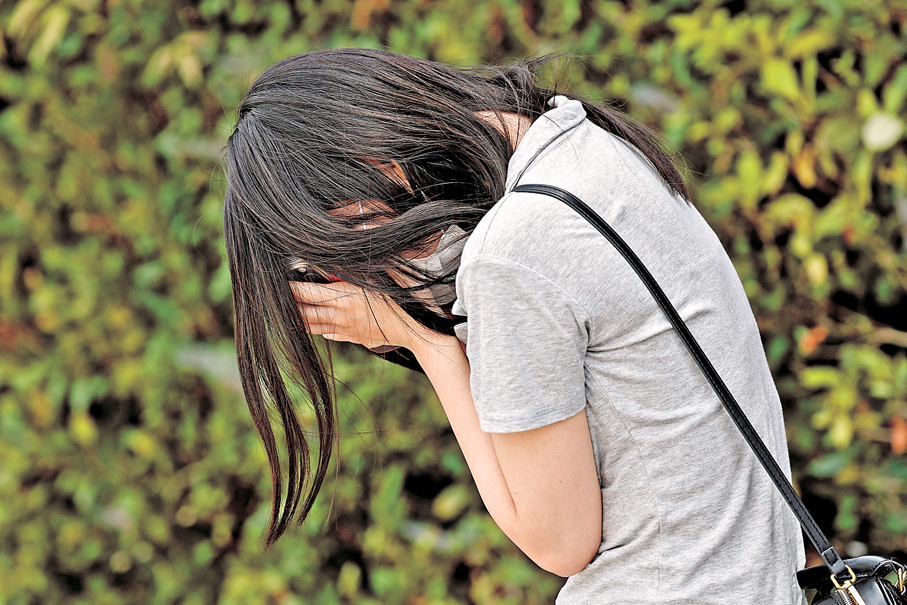 ●一名女士在爆炸商場外低頭哭泣。 路透社
