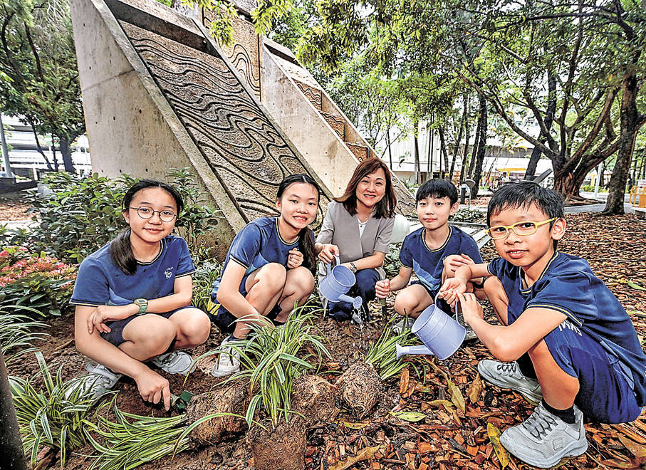 ●小學生鍾嶅仁（右一）、吳心祈（左一）和其他同學，在老師謝怡（中）帶領下一同參與種植活動。