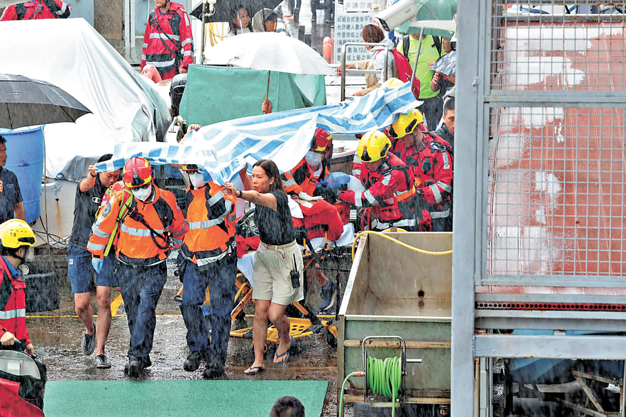 ●失蹤參賽者由消防蛙人潛入海底救回上岸，救護員一直施行急救並由救護車送院，惜終告不治。香港文匯報記者劉友光  攝