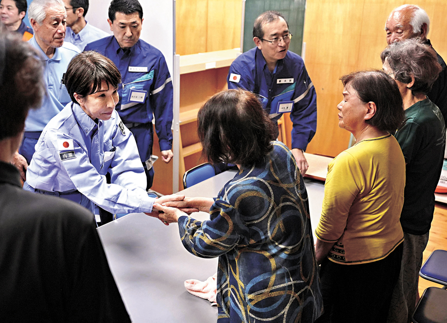 ●高市觀察避難所情況，與災民握手慰問。 美聯社