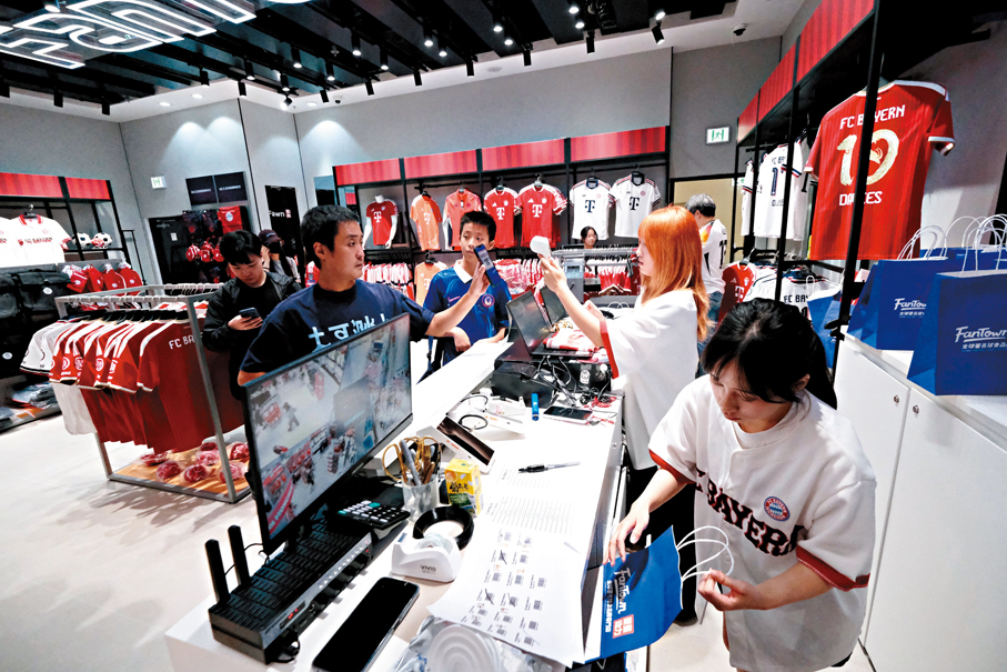 ●不少球迷到啟德零售館內一家球會精品店內，選購拜仁慕尼黑的新球季球衣。 香港文匯報記者涂穴 攝