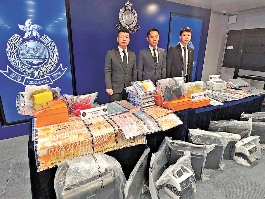 ●警方展示行動中檢獲的證物包括現金、手袋及電腦。香港文匯報記者劉友光  攝