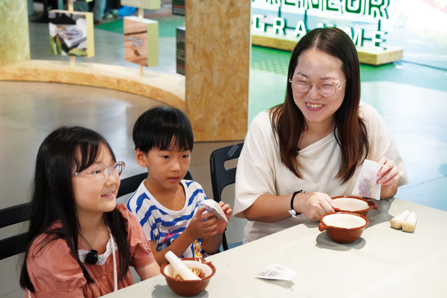 ▲家長帶同子女參與香包工作坊，透過動手實作讓孩子認識循環再用概念，培養環保意識。