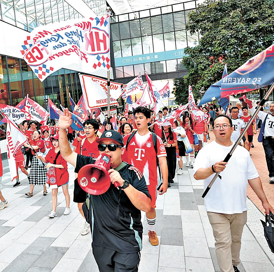 ●拜仁慕尼黑香港官方球迷會賽前特意組織「旗海」，向啟德主場館進軍先聲奪人。   香港文匯報記者郭正謙  攝