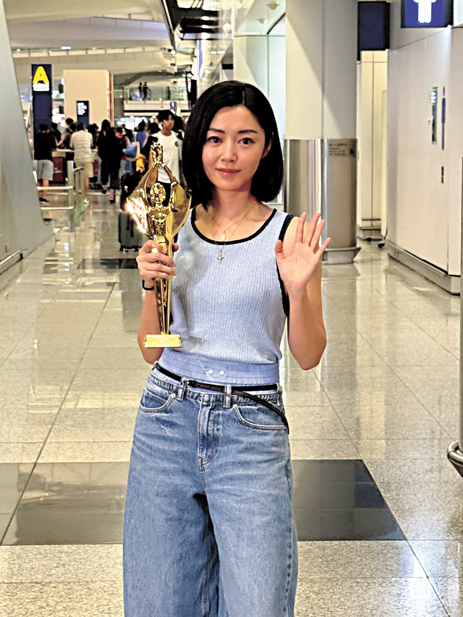 ●衛詩雅機場手捧獎座見傳媒。 香港文匯報記者阿祖 攝
