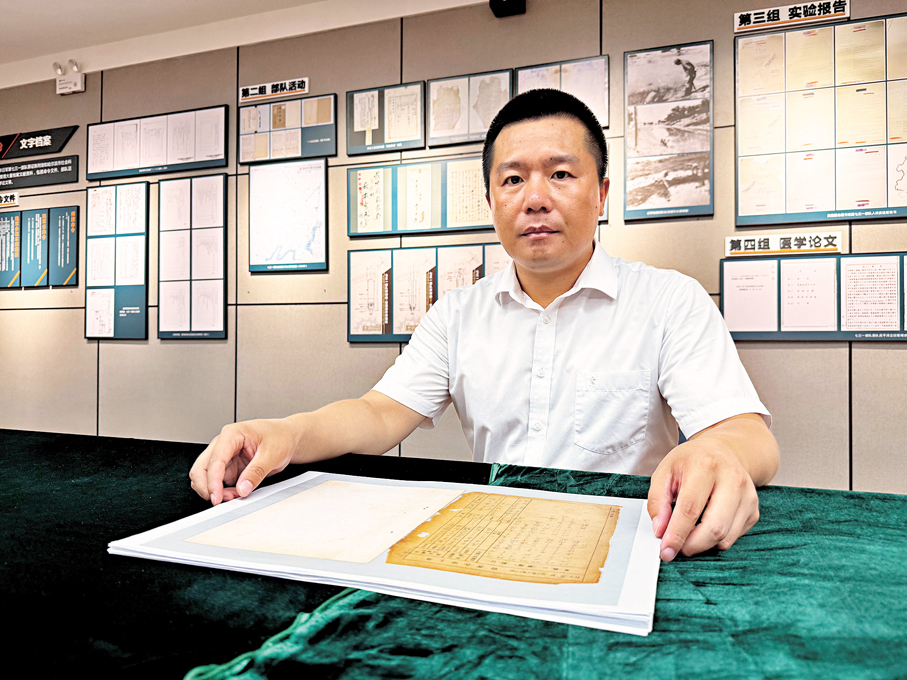 ●侵華日軍第七三一部隊罪證陳列館宣傳教育與陳列部主任金士成向記者展示侵華日軍第七三一部隊海拉爾支隊《身上申告書》檔案。香港文匯報記者于海江  攝