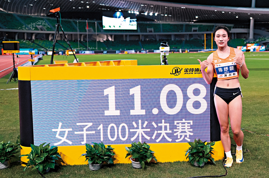 ●陳妤頡在女子100米決賽後，與成績顯示屏合影。 新華社