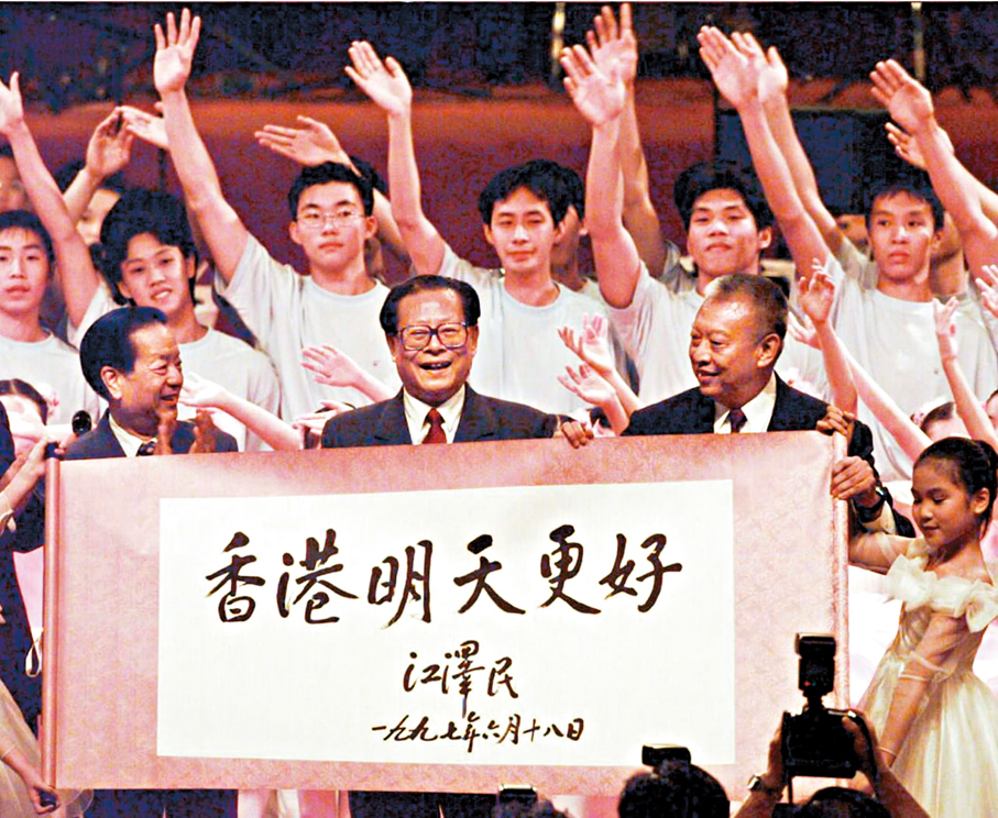 ●1997年7月1日上午10時，在香港特別行政區成立慶典上，少年兒童展示江澤民主席題寫的「香港明天更好」書法卷軸。 資料圖片