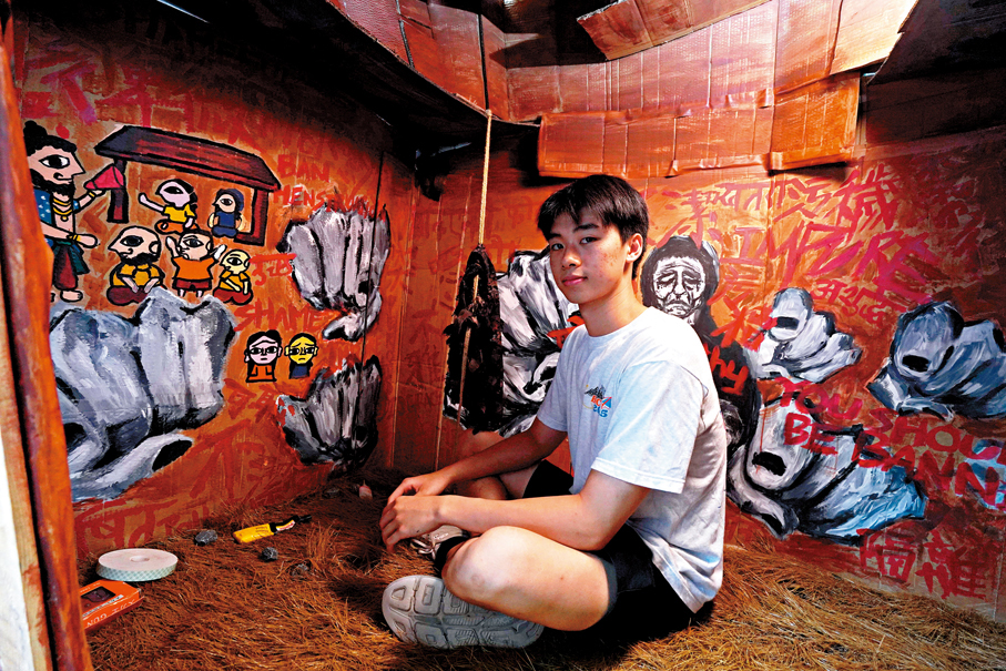 Brian坐在「月經小屋」裝置內，顯示尼泊爾女性在來經日子被迫在狹窄的環境中生活。