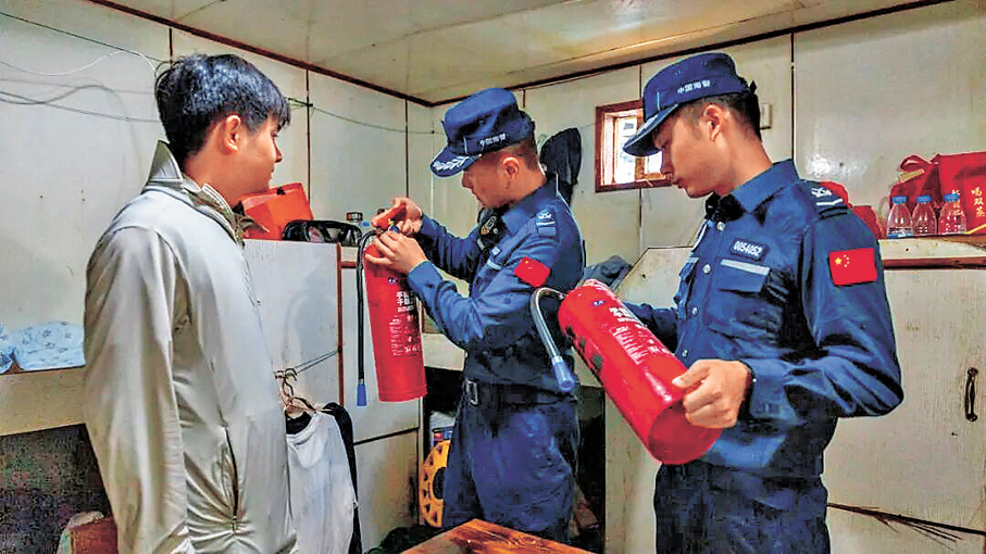 ●海警執法員幫助漁民檢查船舶安全設施設備。   中國海警公眾號圖片