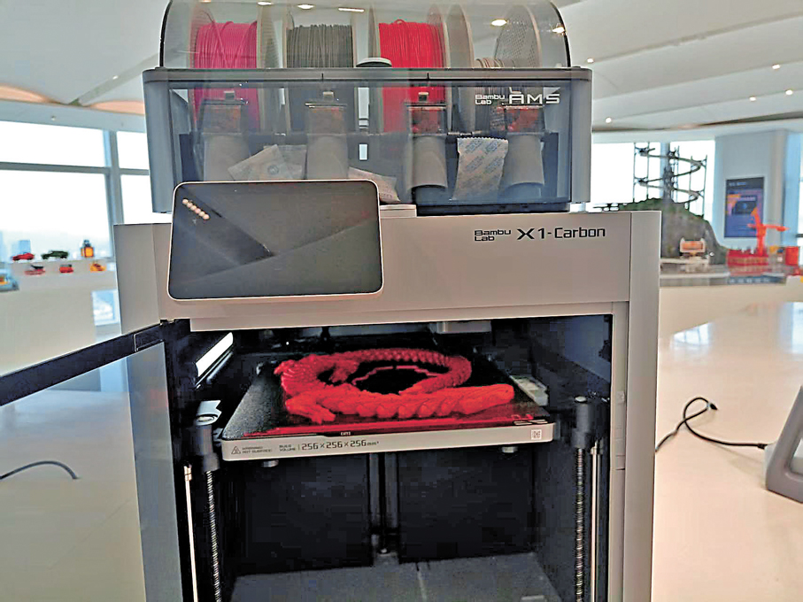 ●拓竹科技3D打印機在打印龍形玩具。   香港文匯報記者李昌鴻  攝