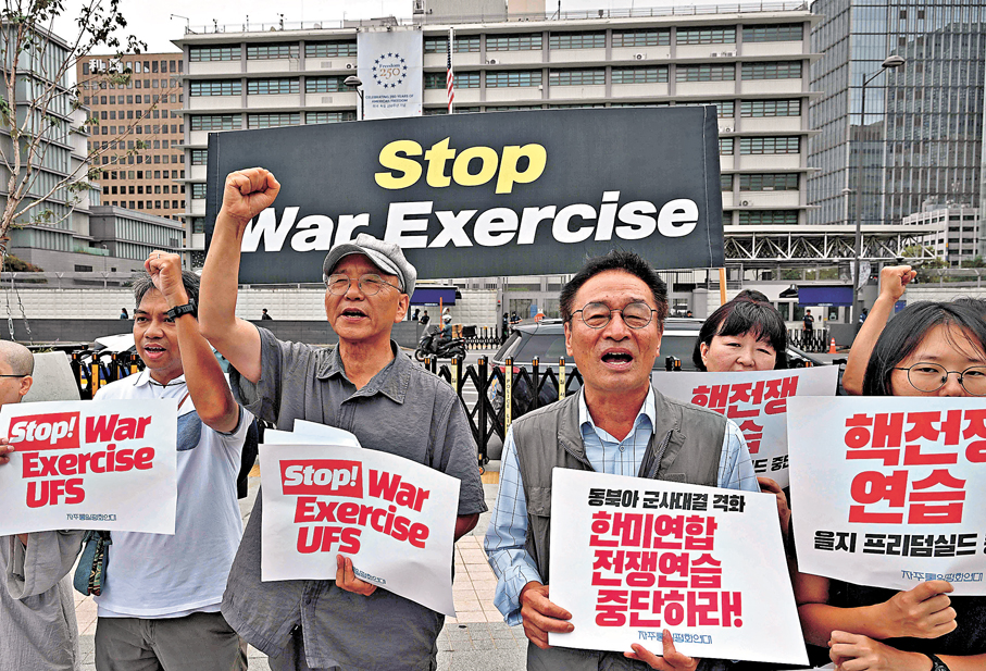 ●首爾民眾發起集會，舉起標語反對美韓聯合軍演。法新社