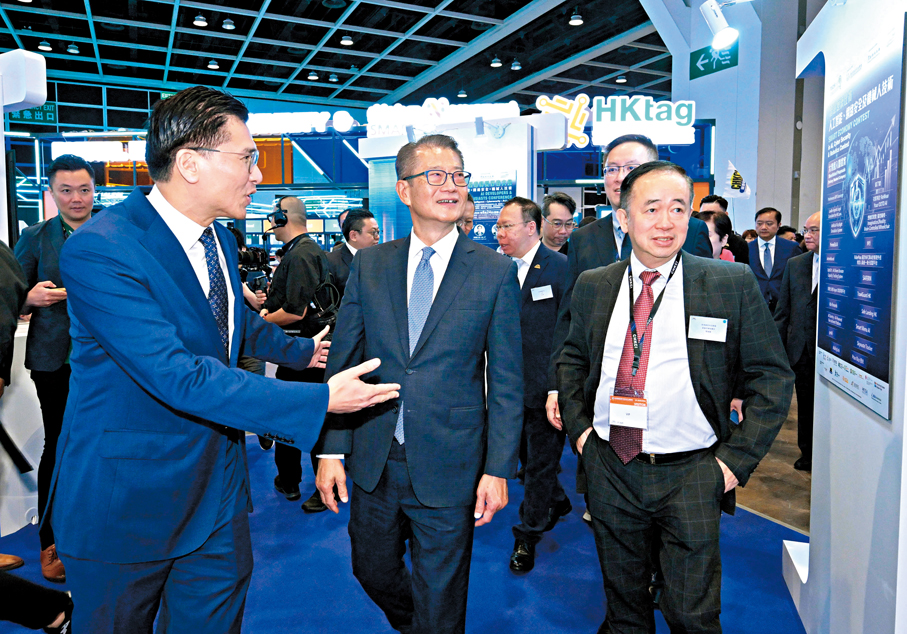 ●陳茂波表示，AI的應用場景正不斷擴闊，亦帶來很多新的可能。圖為陳茂波（中）在電腦通訊節場內參觀。政府新聞處圖片