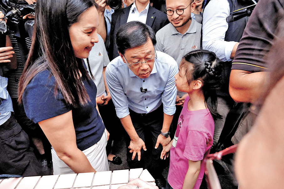 ●李家超與趙女士（左）母女交流。 香港文匯報記者涂穴 攝