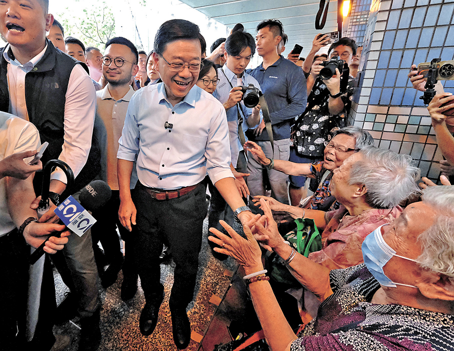 ●李家超在元州邨和市民交流。香港文匯報記者涂穴  攝