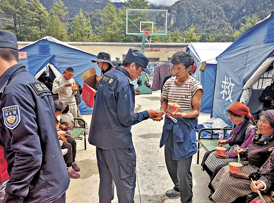 ●8月27日，民輔警在集中安置點分發食物。 新華社