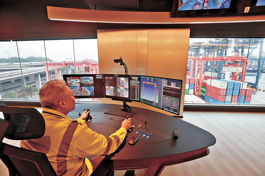 ●中遠—國際貨櫃碼頭進行智能化轉型。圖為操作員透過控制台遙距操控龍門架吊機。香港文匯報記者郭木又 攝