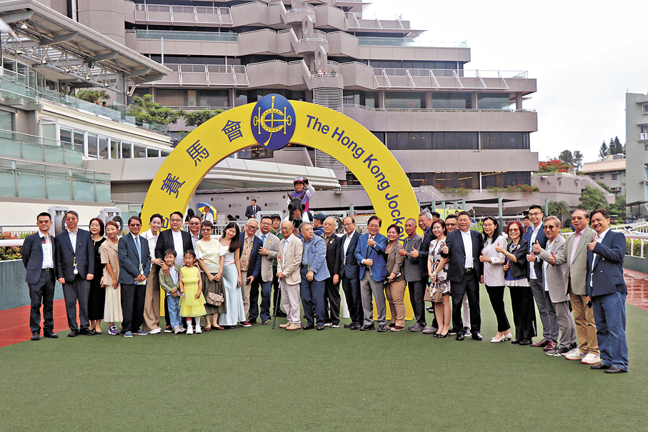 ●貝鈞奇（右十四，箭嘴示）和好友組成的「會友團體」的馬匹「齊歡最樂」於今年5月17日的比賽中獲勝。圖為馬主「會友團體」一起牽頭馬。 香港文匯報記者鄭凱迪  攝