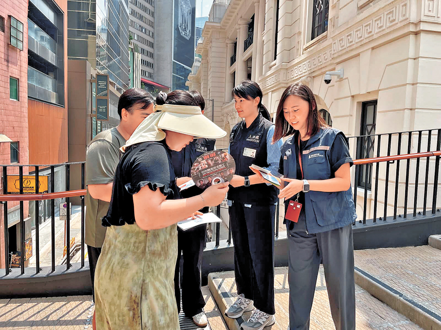 ●入境處及旅監局人員向市民及旅客派發宣傳單張，呼籲切勿聘用非法領隊或導遊。 政府新聞處